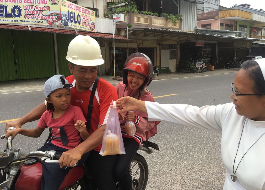 Kepala SMP Regina Pacis, Sr. Ancilla, FcH turut membagikan takjil pada bulan Ramadhan